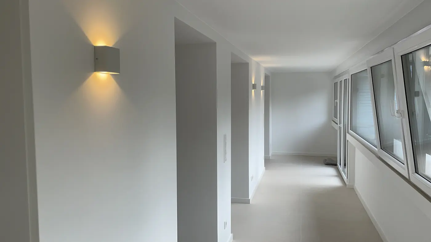 Heller Flur mit warm leuchtenden Wandleuchten