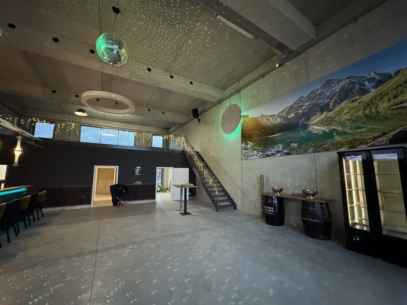 Veranstaltungshalle mit Treppe, Wandbild und stimmungsvoller Beleuchtung