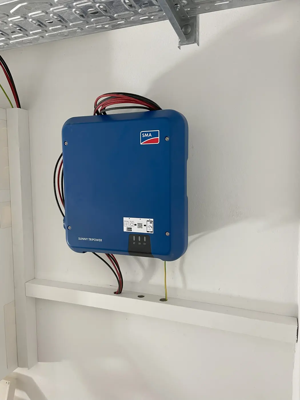 Blauer SMA-Wechselrichter an der Wand mit sauber geführten Leitungen