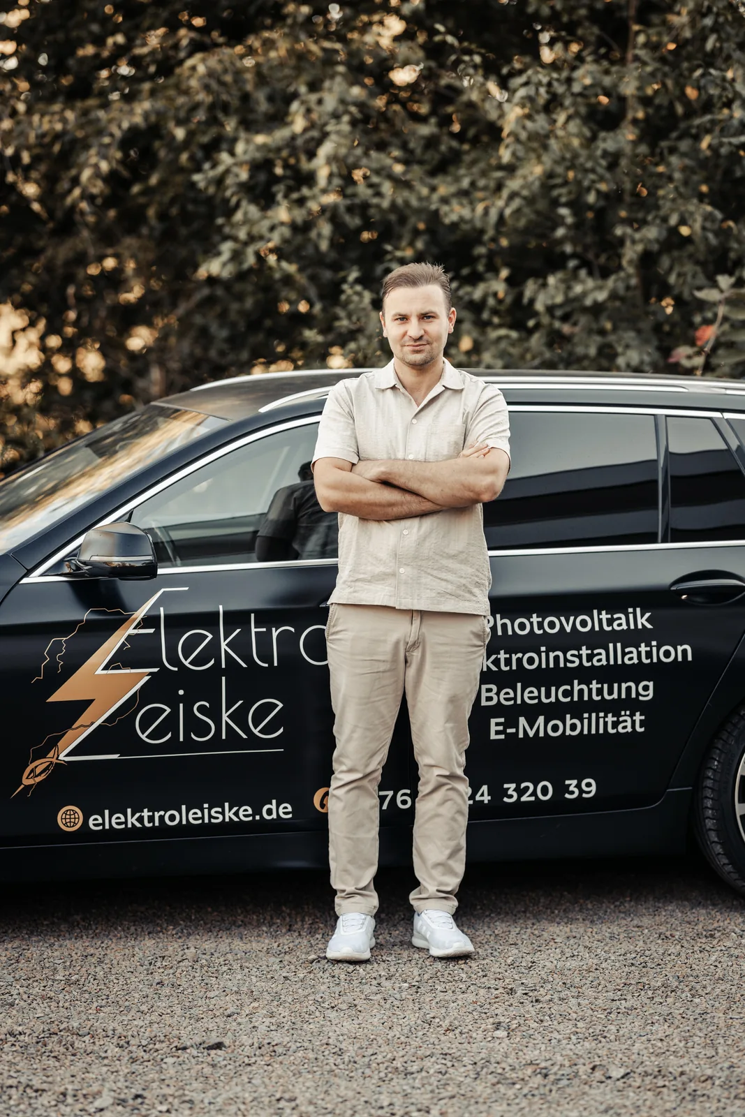 Peter Leiske, Inhaber von Elektro Leiske, vor dem beschrifteten Firmenwagen